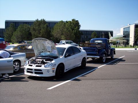 1972 Ford Ranchero - A white Dodge Neon SRT-4 is displayed with its hood open, alongside other vehicles in a parking lot.