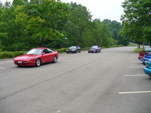 1991 Ford Probe - A red 1991 Ford Probe GT is seen driving on a paved road with trees in the background.