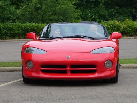 1991 Ford Probe - A red convertible sports car is parked outdoors, with two people visible in the interior.
