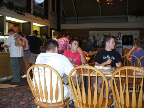 1991 Ford Probe - Diners are seated at tables inside a restaurant, with some standing in line at a counter in the background.