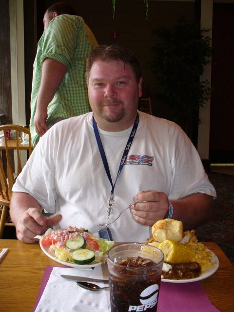 1991 Ford Probe - A man enjoys a meal at a table, with a salad and a plate of food in front of him.