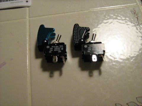 1988 Mercury Grand Marquis - Two toggle switches are shown, each with a different style of protective cover. Text on the switches indicates electrical ratings.