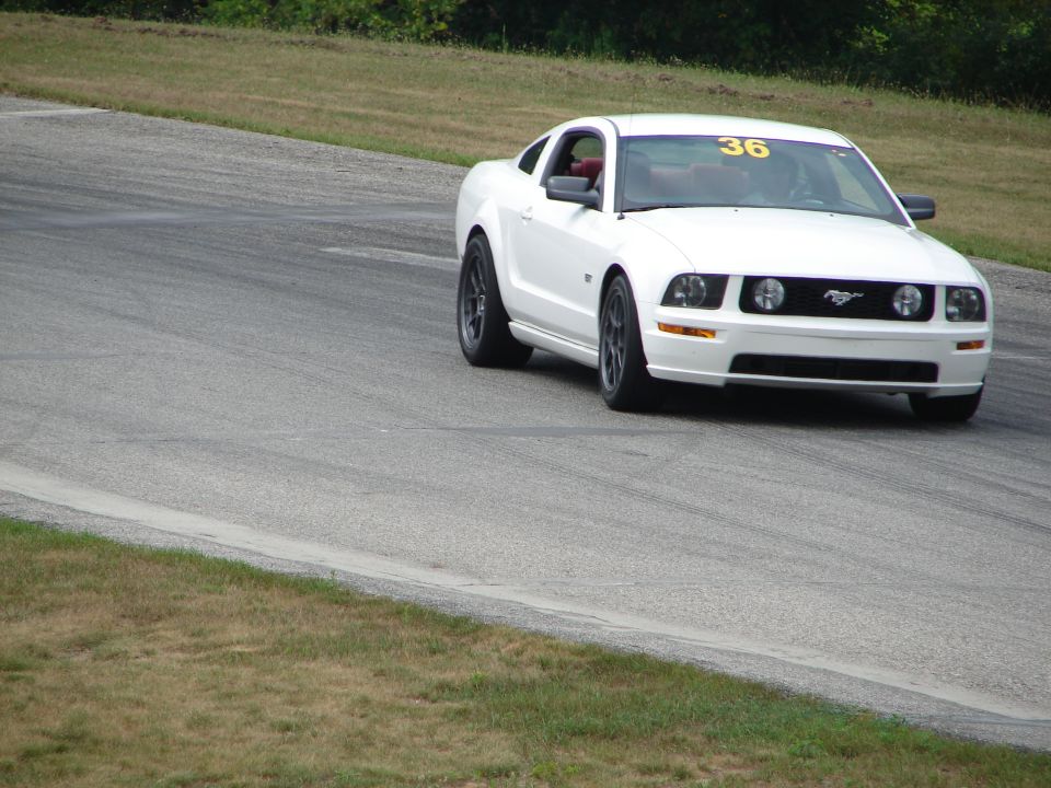 White Ford Mustang with racing number 36 on windshield, on a race track