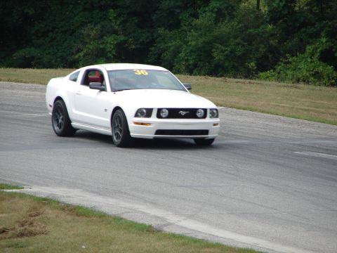 1993 Ford Taurus - A white coupe with racing number 36 on the windshield navigates a turn on a race track.