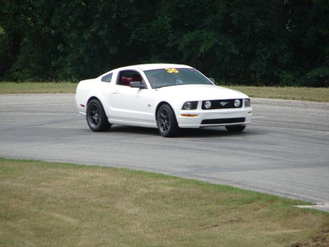 1993 Ford Taurus - White 2005 Ford Mustang on a race track, displaying the number 36 on its windshield.
