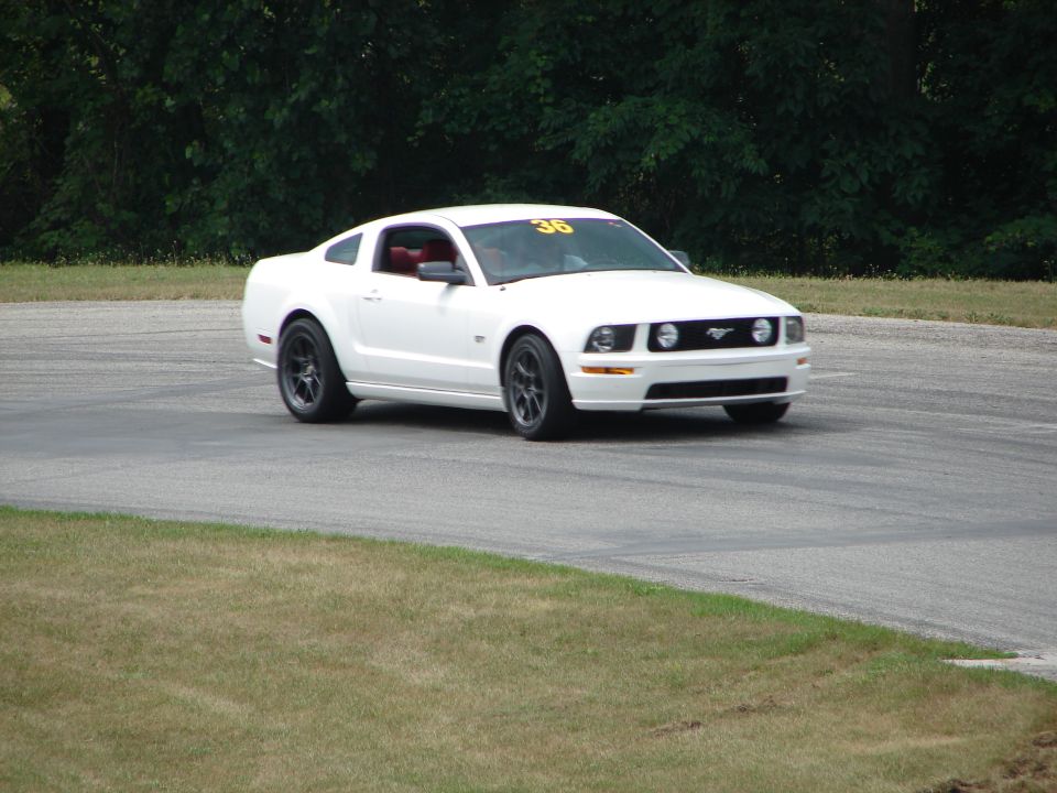 White 2005 Ford Mustang on a race track with number 36 on windshield