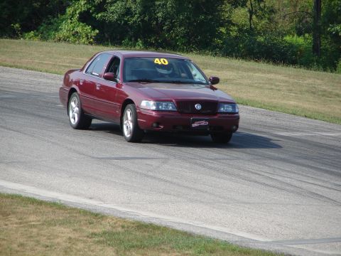 1993 Ford Taurus - Maroon sedan with racing number 40 on windshield navigates a turn on a race track.