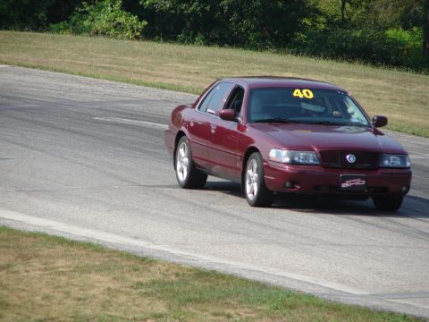 1993 Ford Taurus - Red sedan with racing number 40 on windshield driving on a race track.