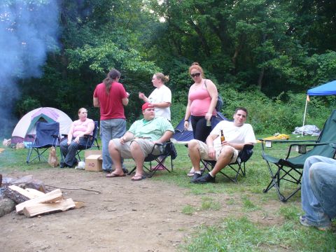 1991 Ford Probe - A group of friends enjoy a camping trip with tents and a campfire visible.