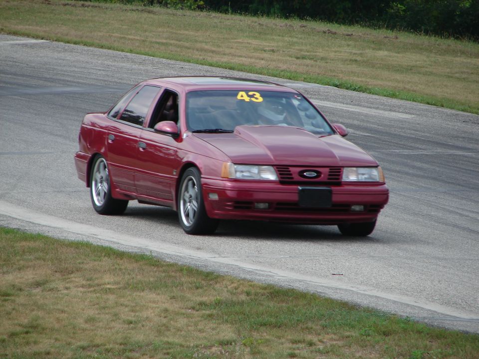Red 1993 Ford Taurus with racing number 43 on windshield