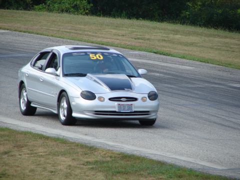 1993 Ford Taurus - A silver sedan with a racing number is on the track, possibly during a competition or practice session.