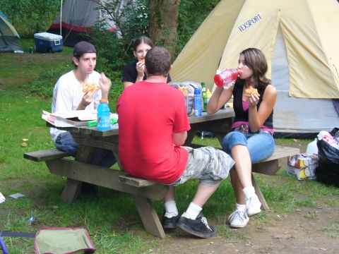 1991 Ford Probe - People enjoy a meal outdoors at a campsite with tents in the background.