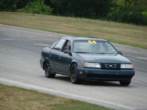 1993 Ford Taurus - A 1993 Ford Taurus with racing number 54 is seen on a road course.