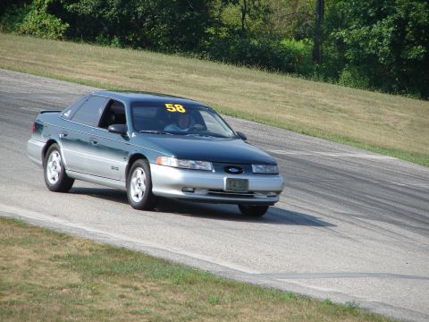 1993 Ford Taurus - A 1993 Ford Taurus competes on a road course, displaying the number 58 on its windshield.