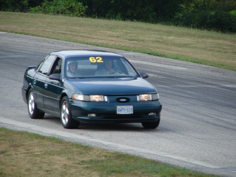 1993 Ford Taurus - A 1993 Ford Taurus competes on a road course, displaying the number 62.