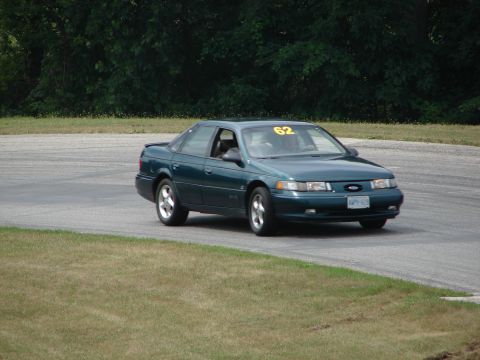 1993 Ford Taurus - This 1993 Ford Taurus, identified by its body style and front grille, is seen on a road course with racing number 62 displayed.