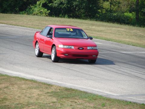 1993 Ford Taurus - Red 1993 Ford Taurus navigates a turn on a road course.