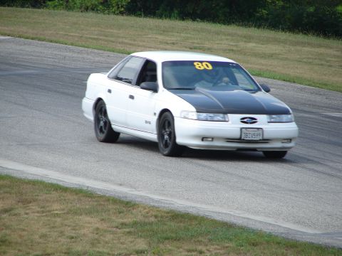 1993 Ford Taurus - This 1993 Ford Taurus is seen on a road course, distinguished by its white body and contrasting black hood.