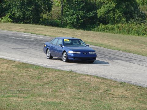 1993 Ford Taurus - A blue 1995 Ford Taurus competes on a road course, displaying the number 83.
