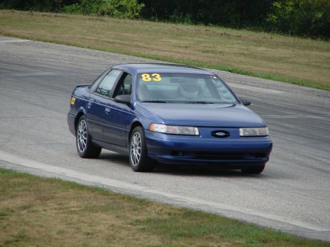 1993 Ford Taurus - A blue 1993 Ford Taurus is seen on a race track, displaying the number 83.