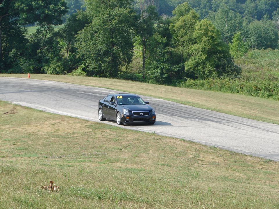 Black Cadillac sedan on a race track with number 86 on windshield