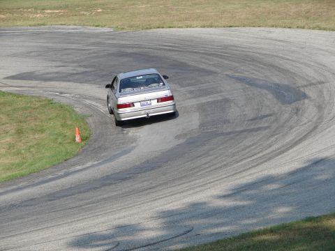 1993 Ford Taurus - Silver 1993 Ford Taurus navigates a turn on a race track, leaving tire marks.