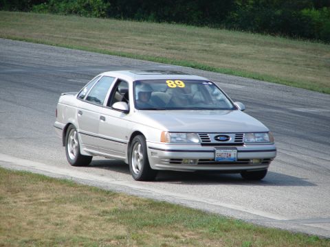 1993 Ford Taurus - A silver 1993 Ford Taurus is seen on a race track with the number 89 displayed on its windshield.