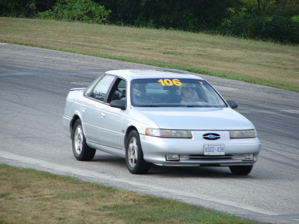 1993 Ford Taurus on a race track, number 106 on windshield