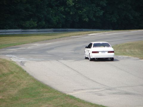 1993 Ford Taurus - A white 1993 Ford Taurus sedan navigates a turn on a road course.