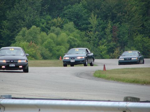 1993 Ford Taurus - Three Ford Tauruses compete on a road course, with car number 78 leading the pack.
