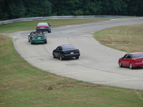 1993 Ford Taurus - Multiple vehicles navigate a winding road course during a track day event.