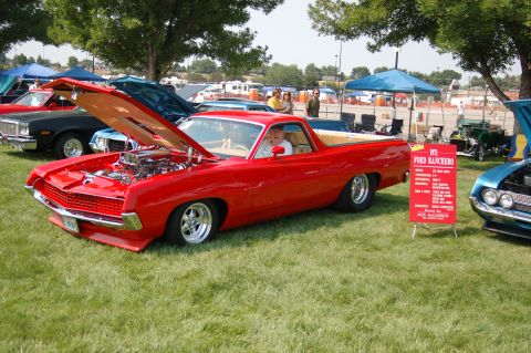1967 Ford Ranchero - A red 1971 Ford Ranchero is displayed with its hood open, revealing a custom engine at a car show.
