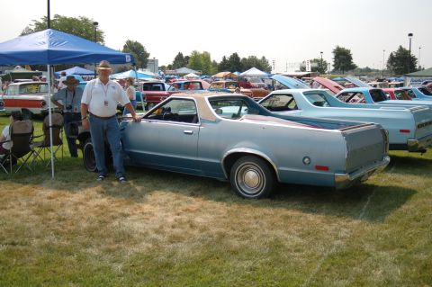 1967 Ford Ranchero - A light blue Ford Ranchero is parked on grass at an outdoor car show with other vehicles in the background.