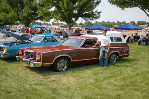 1967 Ford Ranchero - A man poses with his pickup truck at an outdoor car show.