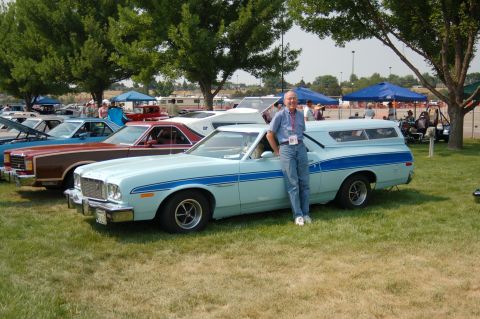 1967 Ford Ranchero - Man poses with a light blue 1972 Ford Ranchero at an outdoor car show.
