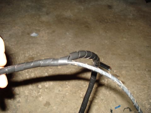 1967 Ford F-250 - A close-up view shows a section of a vehicle's wiring harness, black spiral wrap and a glimpse of exposed copper wire.