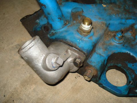 1967 Ford F-250 - Close-up of a cast iron engine component, painted blue, with a brass fitting attached.