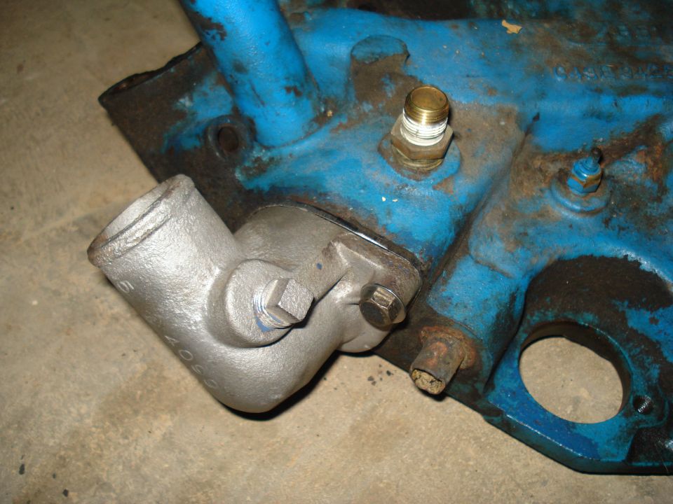 Cast iron engine part with blue paint and brass fitting