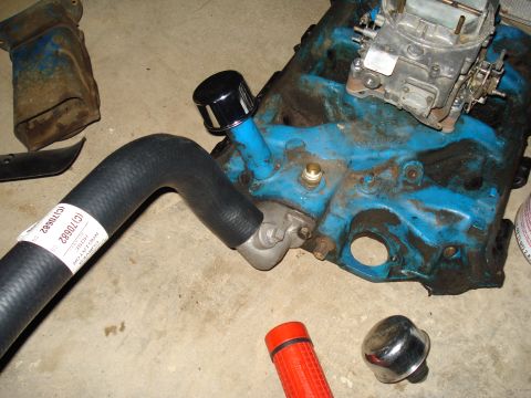 1967 Ford F-250 - Engine block with carburetor and attached hose, parts laid out on a concrete floor.