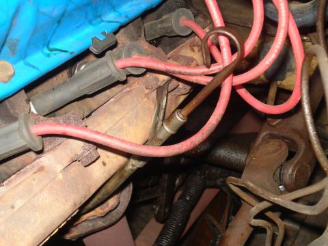 1967 Ford F-250 - Close-up view of engine components, including spark plug wires and exhaust manifold, in a vehicle's engine bay.