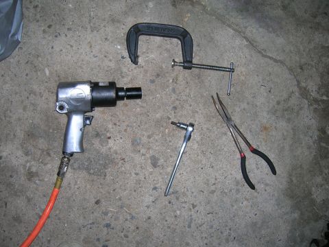 1994 Ford Probe - A collection of automotive tools, including an air impact wrench, are laid out on a concrete surface.