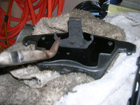 1994 Ford Probe - A brake pad is shown with a metal clip and a tool. The word "OFF" is visible on the pad.