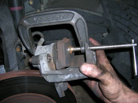 1994 Ford Probe - Compressing brake caliper piston with a C-clamp.