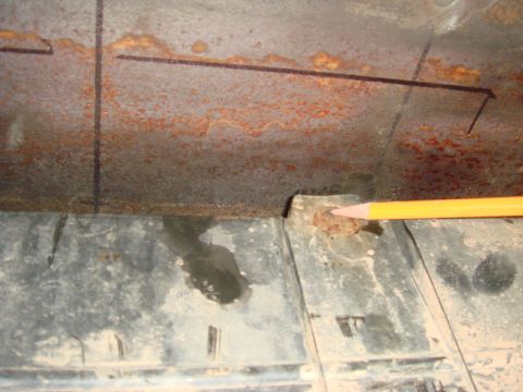 1996 Ford Bronco - A pencil points to a rusted bolt head on a textured plastic surface, with heavily rusted metal above.