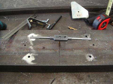 1996 Ford Bronco - Tools and a metal plate are laid out on a workbench, suggesting preparation for a mechanical task.