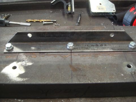 1996 Ford Bronco - Metal bracket assembly with tools on a workbench, likely for a winch installation.
