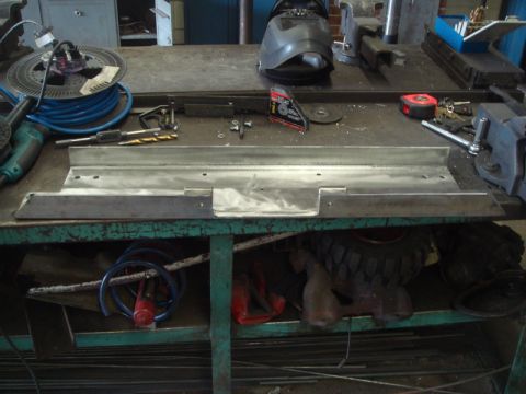1996 Ford Bronco - Tools and metal parts are laid out on a workbench, suggesting a fabrication project is underway.