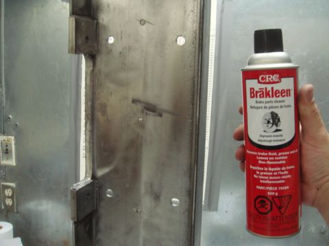 1996 Ford Bronco - A can of CRC Brakleen is held up against a grimy metal panel, showing a close-up of a part and cleaning product.