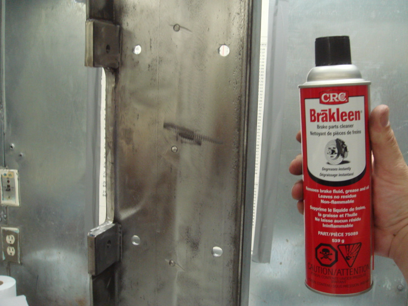 CRC Brakleen can held in front of a dirty metal surface with electrical outlets