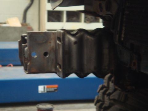 1996 Ford Bronco - The photo shows a close-up of a vehicle's frame and a tire, likely in a workshop setting.